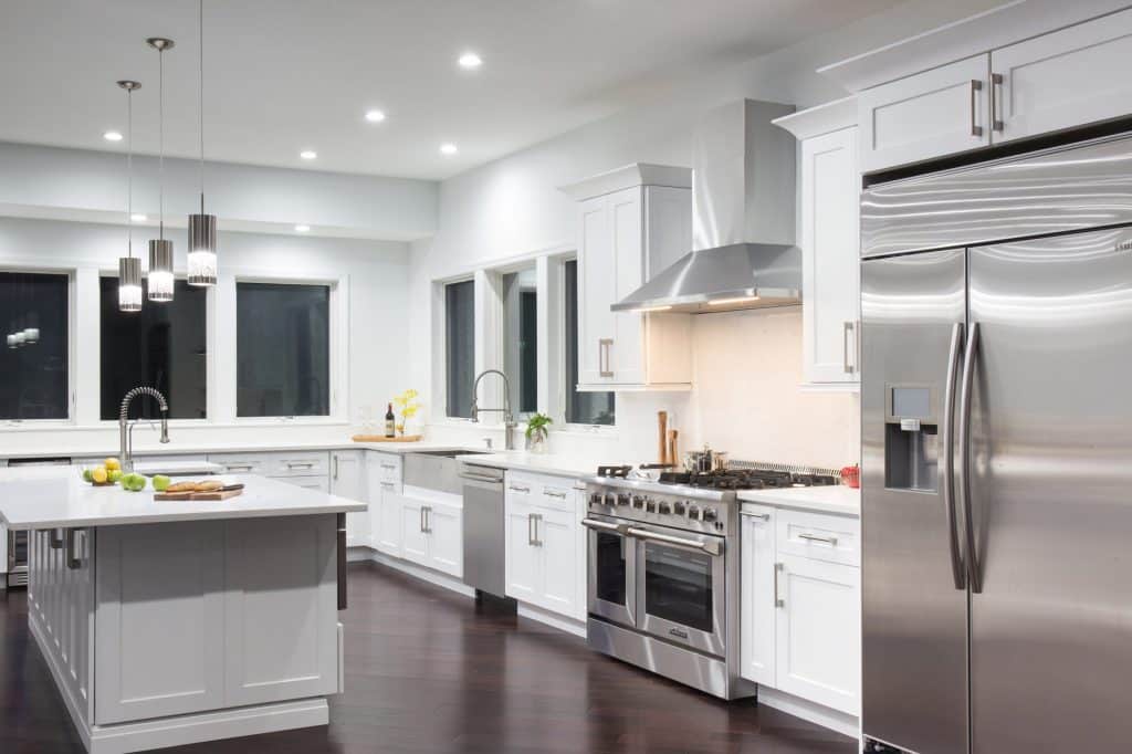 A kitchen with white kitchen cabinets and stainless steel appliances