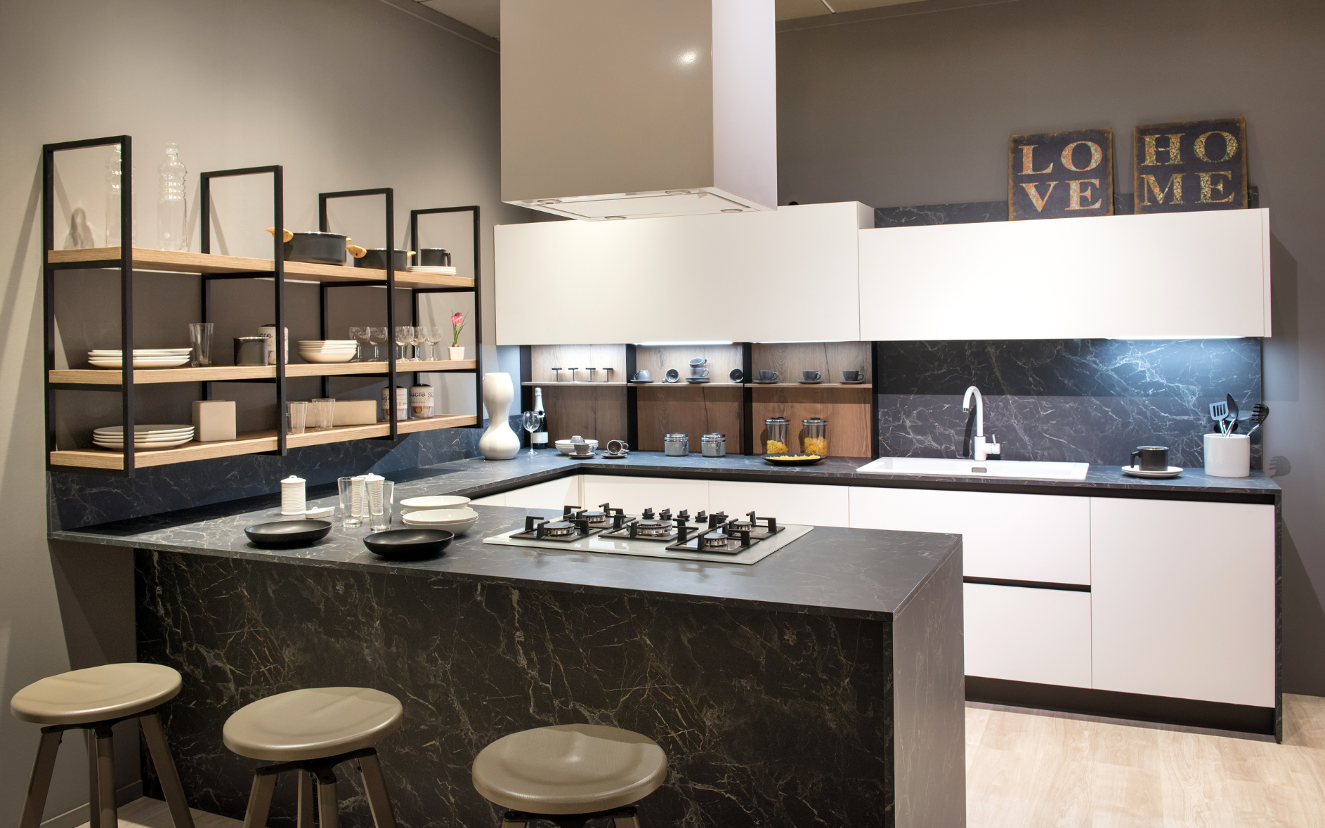 Modern kitchen with floating shelves, black countertop, and white cabinet